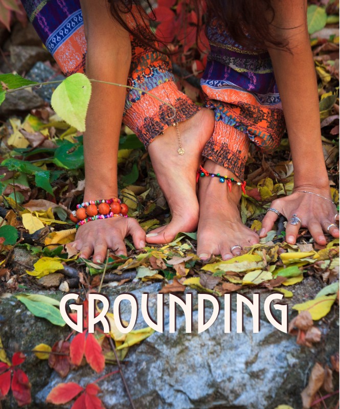 A woman with her feet on the ground in the leaves.